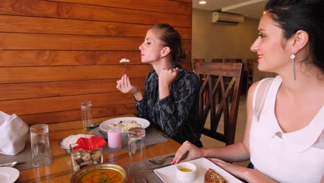Two-Caucasian-females-having-lunch-together-at-a-restaurant-and-the-food-is-tasty
