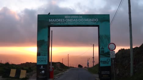 Willkommen-Beim-Schild-Mit-Den-Größten-Wellen-Der-Welt-Am-Strand-Von-Nazaré,-Portugal