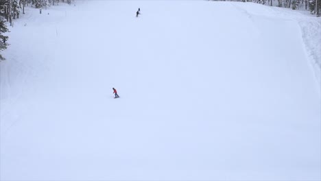 Cámara-Lenta-De-Un-Snowboarder-Bajando-Una-Pendiente-En-Un-Día-Ventoso