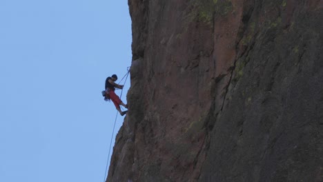 Kletterer-Erklimmt-Eine-Rote-Felsstruktur