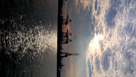 Containerkran-Auf-Der-Insel-Bukom-Im-Hintergrund-Des-Sonnenuntergangs,-Aufgenommen-Vom-Labrador-Steg