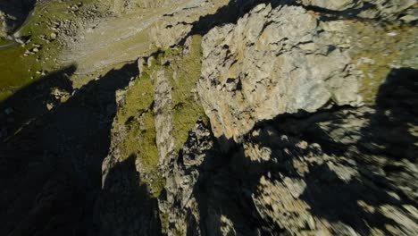 Stunning-acrobatic-flight-with-FPV-fast-drone-over-alpine-mountain-rocky-surface-of-Cima-Fontana-in-Valmalenco
