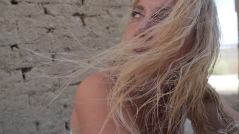 Woman-in-a-white-dress-near-ruins-close-up-with-the-wind-blowing-in-her-hair