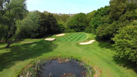 Smooth-Aerial-Flyover-of-English-Golf-Putting-Green,-Bunker-and-Pond