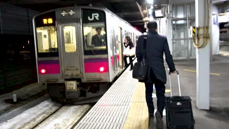 Ein-Geschäftsmann,-Der-Auf-Einen-Kleinen-Zug-Zuging,-Hielt-Am-Bahnhof-In-Aomori,-Japan
