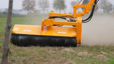Orange-verge-mowing-arm-cutting-grass-while-moving-towards-the-camera
