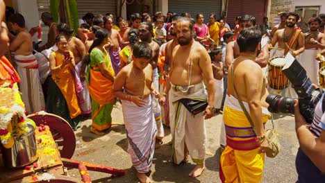 Worshipers-outside-a-Narasimha-Swamy-Hindu-temple-in-Bangalore,-India-preparing-a-shrine-while-musicians-beat-drums