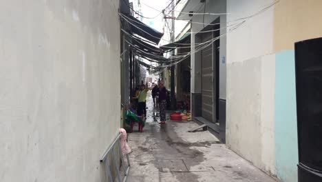People-walking-down-alleyway-in-Da-Nang,-Vietnam
