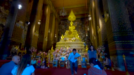 People-pray-in-front-of-the-golden-Big-Buddha-inside-the-Wat-Pho-Temple-in-Bangkok