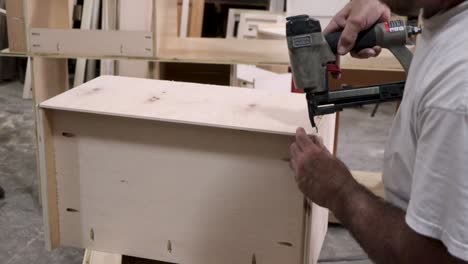 Man-cutting-wood-with-table-saw