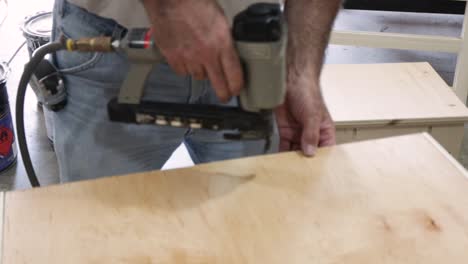 Man-cutting-wood-with-table-saw