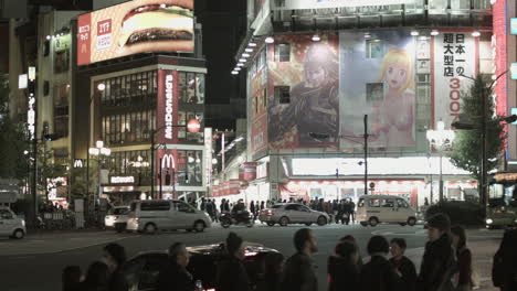 Still-shot-of-a-big-crowd-people-crossing-the-street-during-the-night-in-Tokyo-with-a-lot-of-cars-and-buses