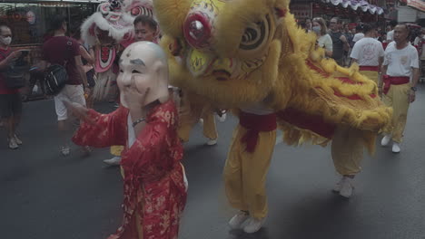 Chinese-New-Year-celebrating-in-Chinatown-Bangkok,-Thailand---traditional-Dragon-dance-on-the-street---People-wearing-masks-because-of-the-new-corona-virus-outbreak---Editorial