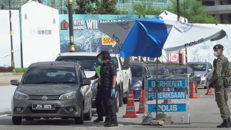 Polizeibeamte-In-Malaysia-überprüfen-Dokumente-An-Einem-Kontrollpunkt