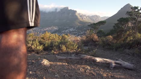Man-walking-towards-Table-Mountain-and-Lions-Head-on-top-of-Signal-Hill-in-Cape-Town,-South-Africa,-in-Slow-Motion