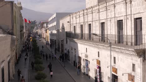 People-walking-on-Santa-Catalina-street-downtown-Arequipa,-Peru-during-sunset