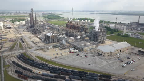 Wide-aerial-shot-over-the-oil-and-gas-refinery-next-to-a-freight-train-station