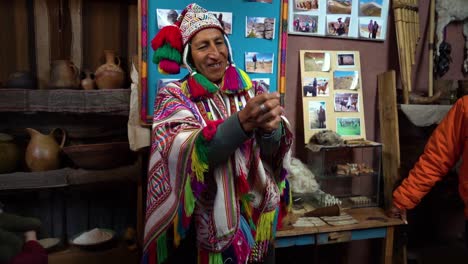 Traditional-dressed-Peruvian-man-showing-Alpaca-thread-used-for-weaving,-slowmo