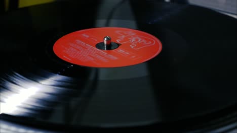 Eine-Schwarze-Vintage-Schallplatte-Mit-Roter-Mittelscheibe-Dreht-Sich-Auf-Einem-Plattenspieler
