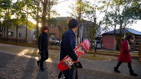 Young-Japanese-skater-friends-walking-in-the-evening-in-urban-Japan
