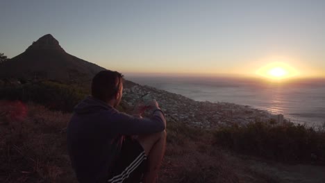 Man-taking-a-picture-of-Cape-Town-with-his-phone-during-Sunset-from-Signal-Hill,-in-Slow-Motion