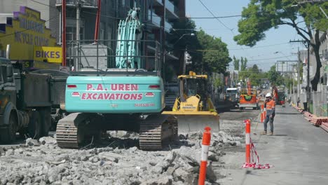 Multiple-diggers-breaking,-digging-up-road-concrete-to-replace-tram-lines