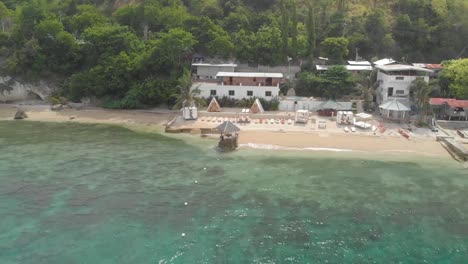 Aerial-orbit,-drone-shot-around-a-resort,-at-a-beach,-near-clear-blue-water,-on-Cebu-island,-in-Philippines,-Asia
