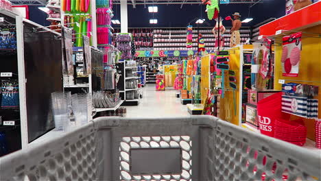 Moving-Down-the-Aisle-of-a-Party-Store-From-the-View-of-Inside-the-Shopping-Cart-with-Merchandise-and-Displays-on-Either-Side-of-the-Cart