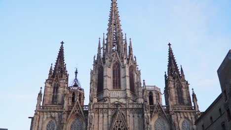 Nach-Oben-Kippende-Aufnahme,-Malerischer-Blick-Auf-Die-Gotische-Katholische-Kathedrale-In-Barcelona,-Spanien,-Blauer-Himmel-Im-Hintergrund