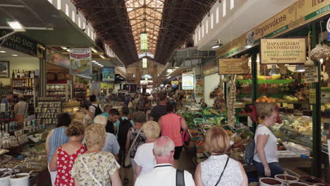 Greek-market-in-Crete,-indoors-with-a-large-crowd-walking-through