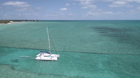 Boat-Sailing-over-Natural-Ocean-Channel-in-Freeport,-Bahamas,-Aerial-Drone