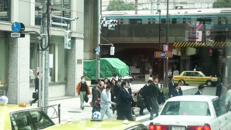 Menschen-überqueren-Die-Straße-Auf-Einem-Fußgängerüberweg-In-Tokio
