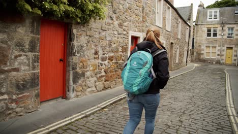 A-woman-wanders-through-an-old-and-empty-Scottish-village