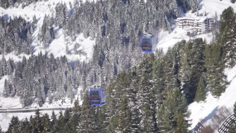 Iconic-cable-cars-located-in-sunny-ski-resort,-filmed-from-above-in-a-helicopter
