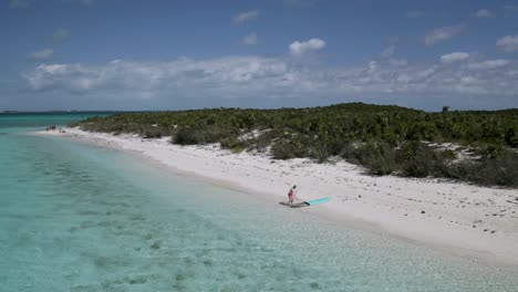 Einsamer-Tourist-Mit-Sozialer-Distanzierung-Am-Weißen-Sandstrand-Auf-Den-Bahamas,-Luftaufnahme