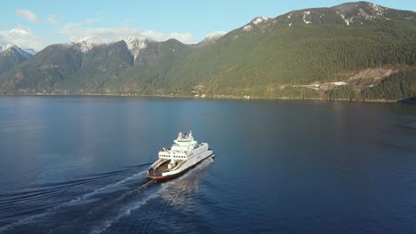 Aerial-of-BC-Ferries-ferry-moving-towards-beautiful-snow-capped-mountainous-landscape