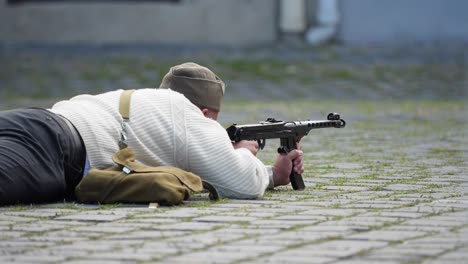 Man-lying-on-the-ground-shoots-with-his-machine-gun