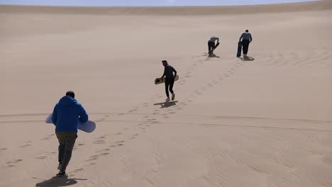 Campers-run-on-the-sand-under-the-hot-sun-in-the-desert-and-make-footprints-on-the-sand---slow-motion
