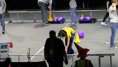 Schüler-Platzieren-Spielsteine-Vor-Einem-Spiel-Bei-Der-Ersten-Robotik-Auf-Dem-Spielfeld