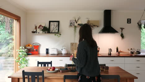 Young-woman-lighting-candles-in-styled-kitchen-and-short-stay-living-accommodation