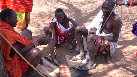 Los-Guerreros-Masai-Juegan-Al-Tradicional-Juego-De-Mesa-Bao.