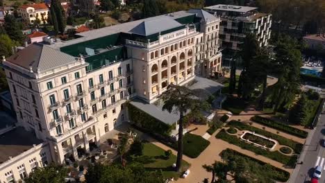 Forward-flying-drone-aerial-tilt-down-view-of-Trieste-Kempinski-palace-hotel,-Italy