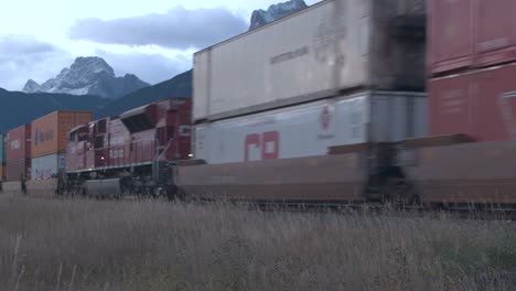 Cargo-freight-train-speeds-through-jagged-Rocky-Mountains