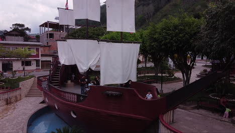 Kids-playing-inside-a-decorative-boat-located-on-central-park-of-Pozuzo,-Peru