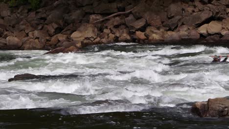 Kayaker-woman-paddling-upstream-in-a-river