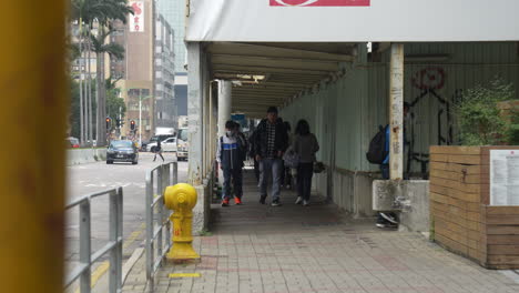 Der-Urbane-Alltag:-Nicht-Wiederzuerkennende-Menschen-Mit-Masken-Gehen-Unter-Einer-Fußgängerbrücke-In-Hongkong-Hindurch