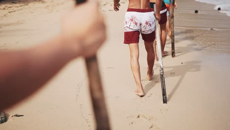 Walking-along-beach-of-Bagamanoc-with-wooden-staff