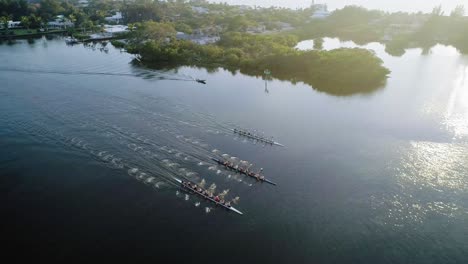 Aerial-Follow-Shot-of-Rowing-Crew-at-Sunset