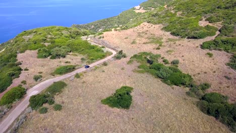 Drone-Aerial-Shot,-following-a-car-on-a-curvy-street-along-the-mediterranean-coast-in-Europe