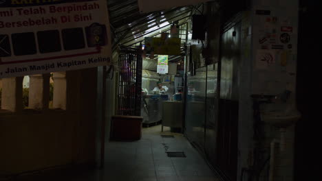 Koch-Bereitet-Essen-In-Einem-Kleinen,-Schwach-Beleuchteten-Restaurant-Zu,-Nacht,-Malaysia